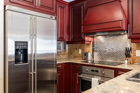- Gourmet kitchen featuring stainless steel appliances and rich cabinetry  
- Granite counters and tile backsplash create a stylish cooking space  
- Equipped for everything from morning coffee to full dinner service