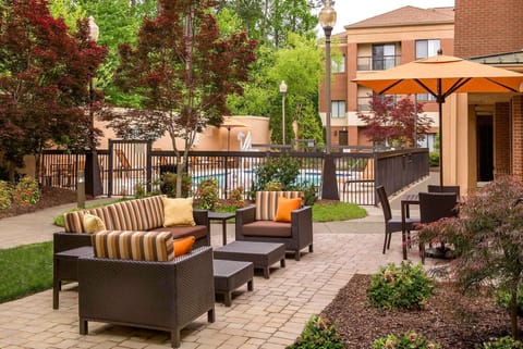 Unwind outdoors on cushioned seating beneath shady umbrellas.