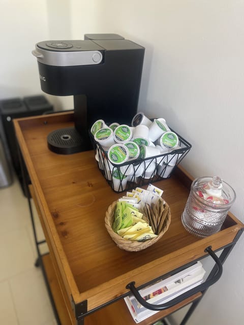 Coffee bar with Keurig coffee maker, french press, kcups, cream, and sugar. 