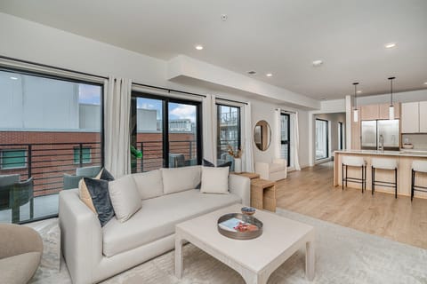Bright open living space featuring Samsung Frame Smart TV, designer furnishings, and access to private patio.