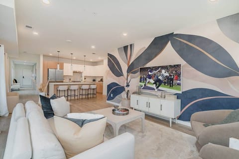 Bright open living space featuring Samsung Frame Smart TV, designer furnishings, and access to private patio.