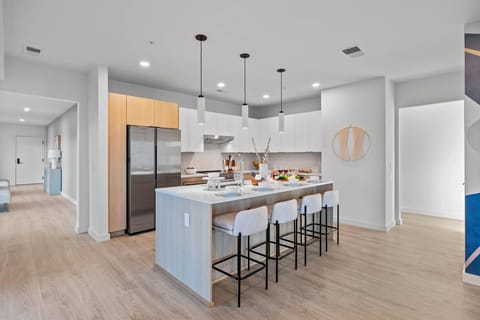 Fully equipped modern kitchen featuring culinary essentials, stainless steel appliances, and island bar seating.