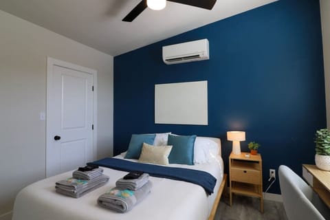 Comfy master bedroom with a striking navy blue accent wall. Relax on a queen memory foam bed with cozy cotton sheets and extra blankets. Ample storage includes a closet with hangers, iron, ironing board, luggage rack, and extra pillows. Plus, enjoy board 