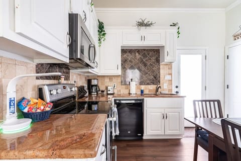 Compact, fully equipped kitchen with electric stove, microwave, and dishwasher — everything you need for easy meals.