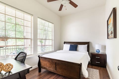 Comfortable queen bedroom with plenty of natural light and a desk for remote work or journaling.