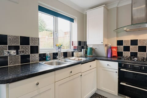 The Kitchen: Looking out over the beautiful garden, there is plenty of storage and all amenities provided.