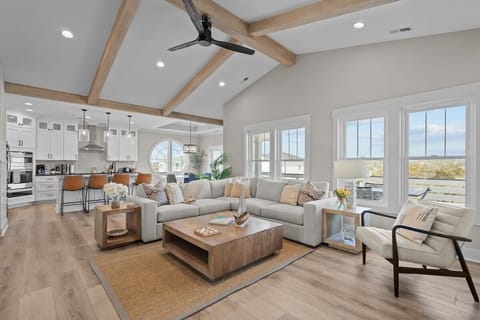 Top Level: Open-Concept Living Area with Seamless Kitchen Flow, Large Windows, and Ceiling Fan