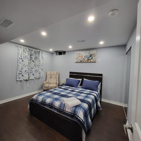 Bedroom 1 with Queen bed and a wing back chair