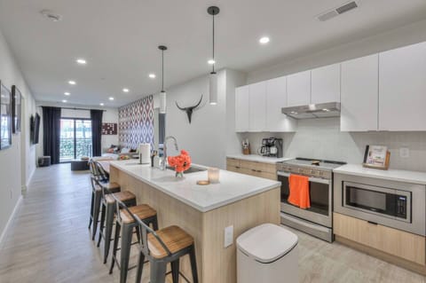 Fully stocked kitchen with modern appliances, bar seating, Alexa, coffee maker, blender, baking basics, BBQ tools, and wine glasses.