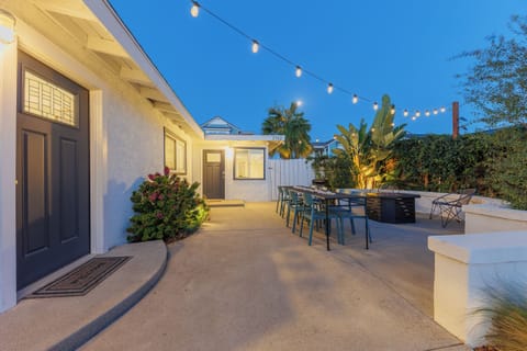 Evening patio with firepit, outdoor dining space, and lush lands