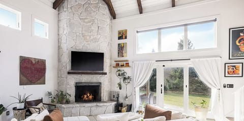 2 story living room, working fireplace and streaming services on TV.