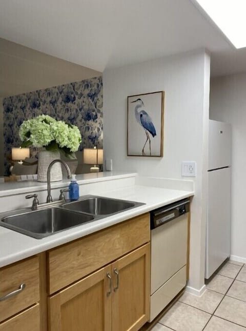 Fridge, dishwasher, and full sink.