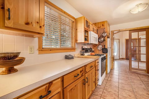 Kittery West Estes Park, Kitchen with lots of counter and cabinet space, gas stove/oven with microwave range hood, refrigerator, looking into entryway.