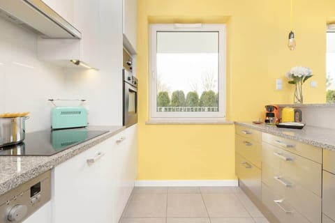 A unique kitchen with white cabinets, stainless steel appliances and minimalist décor.