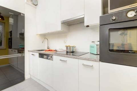 Clean, modern kitchen with white cabinets, stainless steel appliances, and minimalist decor.