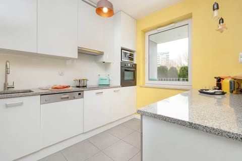 Clean, modern kitchen with white cabinets, stainless steel appliances, and minimalist decor.