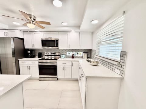 Clean, contemporary, and functional, the kitchen showcases stainless steel appliances, subway tile backsplash, and a large island ideal for entertaining.