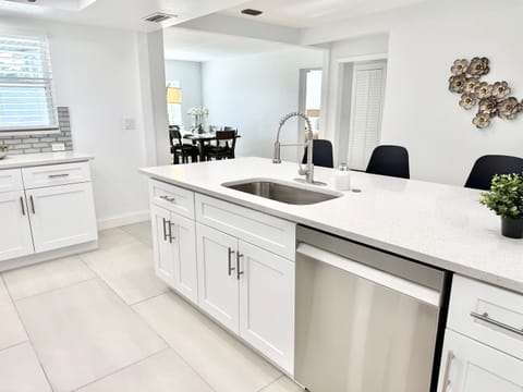 This open-concept kitchen offers sleek finishes, quartz countertops, and a large island with bar stools, creating a functional and stylish centerpiece of the home.