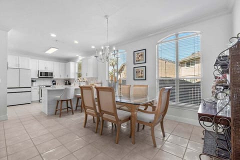 Dining room table for six, next to the barstools in kitchen area.