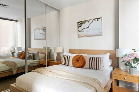 The master bedroom with a queen sized bed & plush pillows.