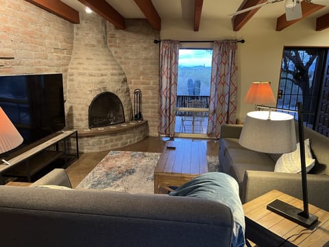 Cozy living room with behive fireplace, 70" TV, and desert & city views.