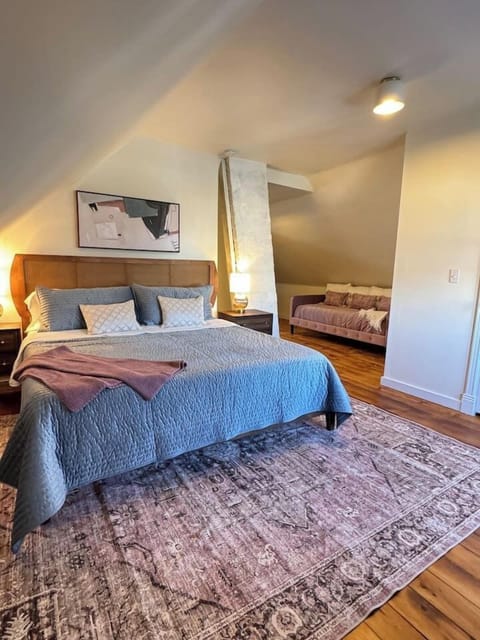 Spacious and stylish bedroom with warm hardwood floors and a plush king bed.