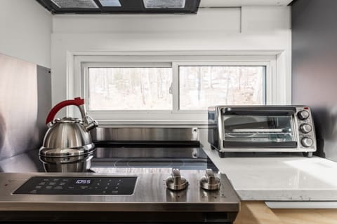 - Sleek stovetop with kettle and toaster oven ready for meal prep   - Airbnb kitchen amenities include cookware for convenient cooking   - Vacation rental provides modern appliances for guest comfort