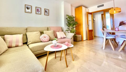 Living room with sea views, large sofa, and dining table. Perfect for relaxing and enjoying your vacation.