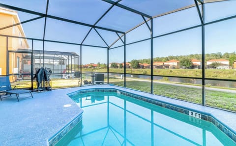 Screened private pool with sun loungers and serene lake views.