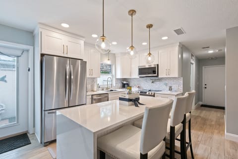 Kitchen is fully equipped w/striking quartz countertops and a waterfall island.
