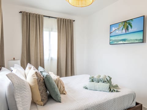 Indulge in Cozy Elegance: A Second Bedroom Oasis with Smart Entertainment at Your Fingertips.
