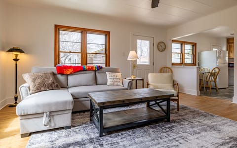 Spacious living room with sleeper sofa, desk, seating and large Smart TV.
