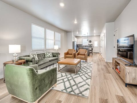 “Elevate your entertainment experience in our inviting living room, complete with a sleek flat-screen TV and warm hardwood floors that exude elegance.”