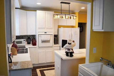 A delightful kitchen, complete with a sink, stove, and refrigerator. A touch of whimsy—a teddy bear in the heart of the room. Experience the joy of a full kitchen with modern amenities, where culinary delights and charm coexist.