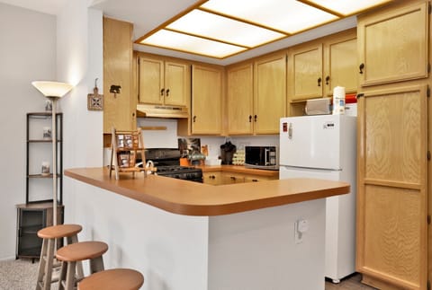 Fully equipped cabin kitchen with ample cabinetry, stove, fridge, microwave, and coffee maker—perfect for cooking meals, morning coffee, and feeling right at home on your stay.