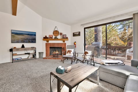 Cozy mountain living room with a fireplace, comfy seating, and smart TV—perfect for relaxing evenings, movie nights, and warm cabin vibes after outdoor adventures.