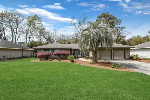 Front Exterior – Welcome to Gone Coastal - A cheerful first impression with a giant palm and manicured lawn—this St. Simons Island beach rental is all charm before you even step inside.