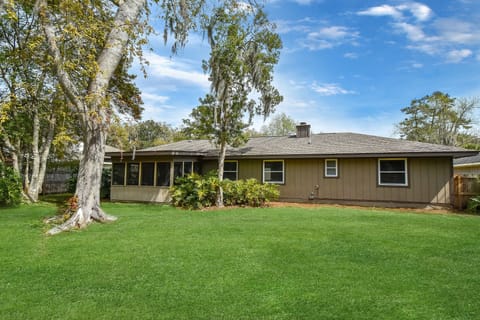 Backyard – Fenced, Grassy, and Pet-Approved - A wide-open fenced backyard with mature trees, lush lawn, and direct access to the screened porch—ideal for pets, games, or soaking up that St. Simons sunshine.