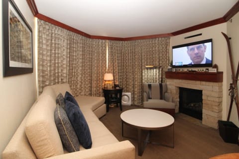 The living area includes a large TV and a propane fireplace