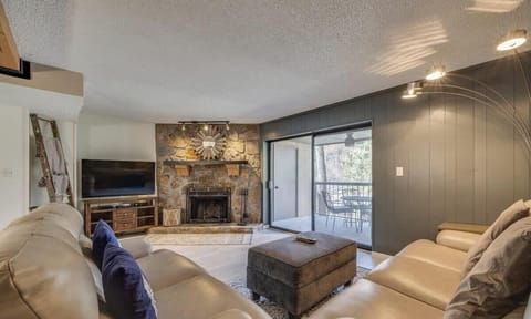 Living Room: Relax by the stone fireplace with scenic views and modern comfort at your fingertips!