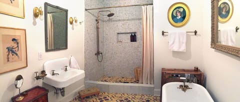 Large bathroom with Moroccan and marble tiles, clawfoot tub, and walk-in shower.