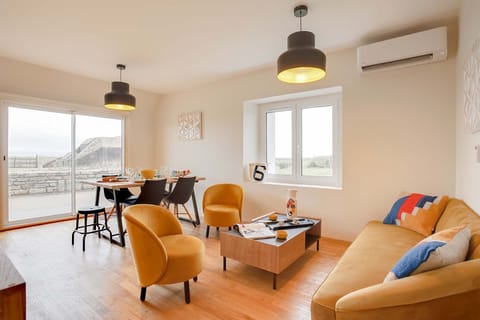 Cosy living space with comfortable seating and dining set against ocean vistas, perfect for unwinding after a day at sea.