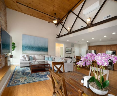 Open kitchen, living and dining areas with beautiful exposed brick walls, wood ceilings and metal beams.