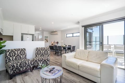 The living room's space charm invites you to unwind on the plush sofa and chairs, with split-system heating and cooling to keep temperatures comfortable.