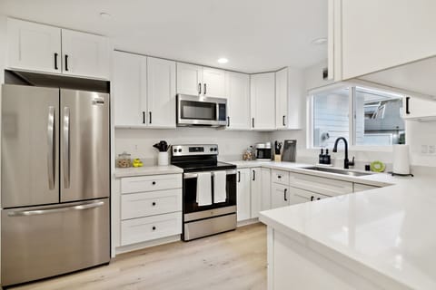 Brand new kitchen with quartz countertops and stainless steel appliances, stocked with everything you'll need to prepare a gourmet meal.