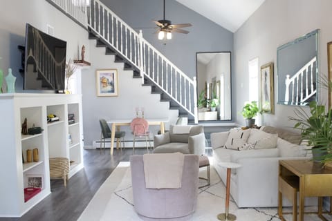 Upstairs living room, with high ceilings, natural light + comfortable furniture