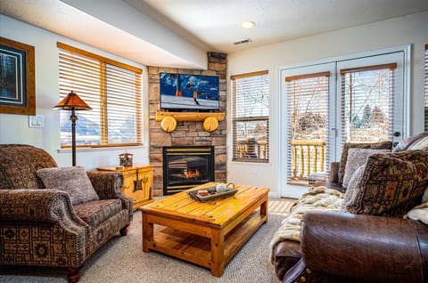 The living room boasts abundant natural light, a welcoming fireplace, and direct access to the balcony.