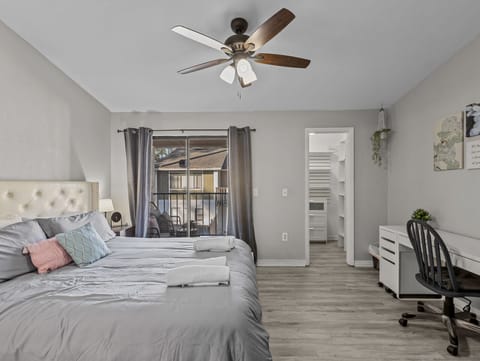 King Bedroom with walk in closet, patio and chairs, and dedicated office desk