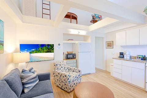 Casual and comfy living space with flat-screen TV, seating, and open kitchen at the Siesta Key 3BR.