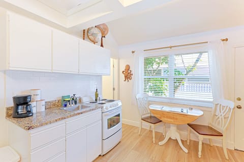 Fully equipped kitchen with oven, coffee maker, and dining nook overlooking the window at the Siesta Key 3BR.